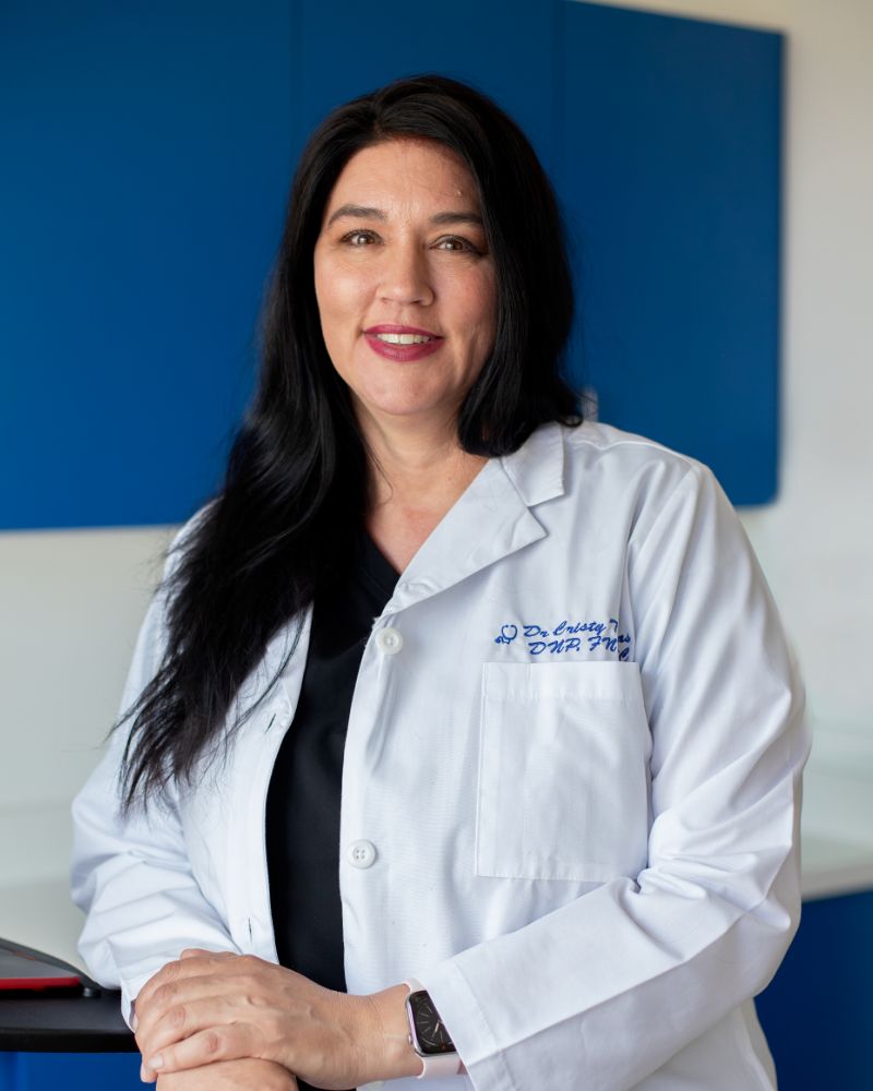 Dr. Cristy Thomas, wearing black scrubs and white lab coat