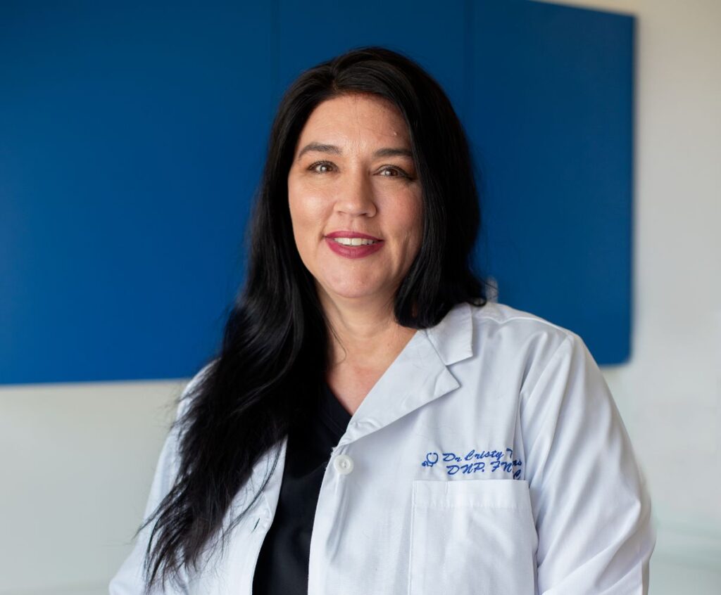 Dr. Cristy Thomas, wearing black scrubs and white lab coat